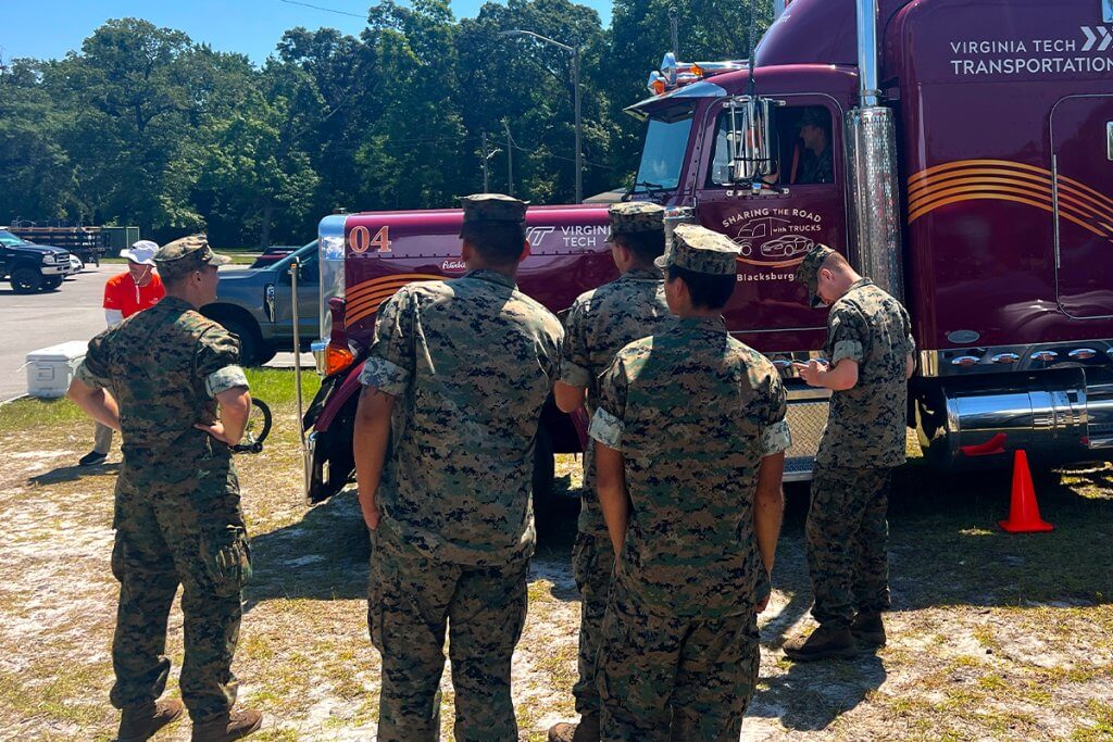 Marines gathered in front of a semi-truck